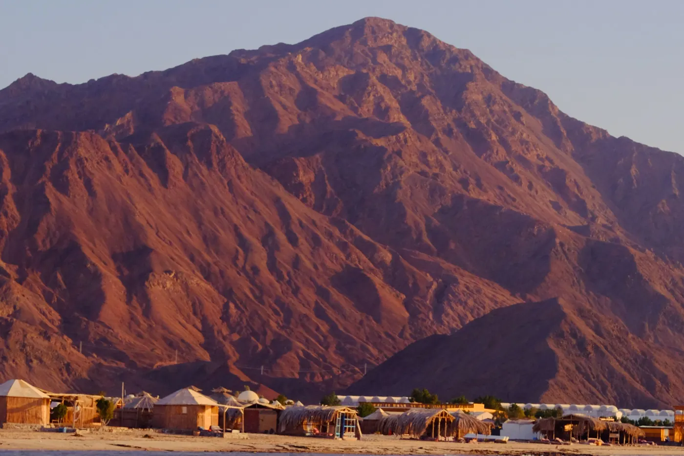 Beach camp huts at Nuweiba below the red mountains of Sinai